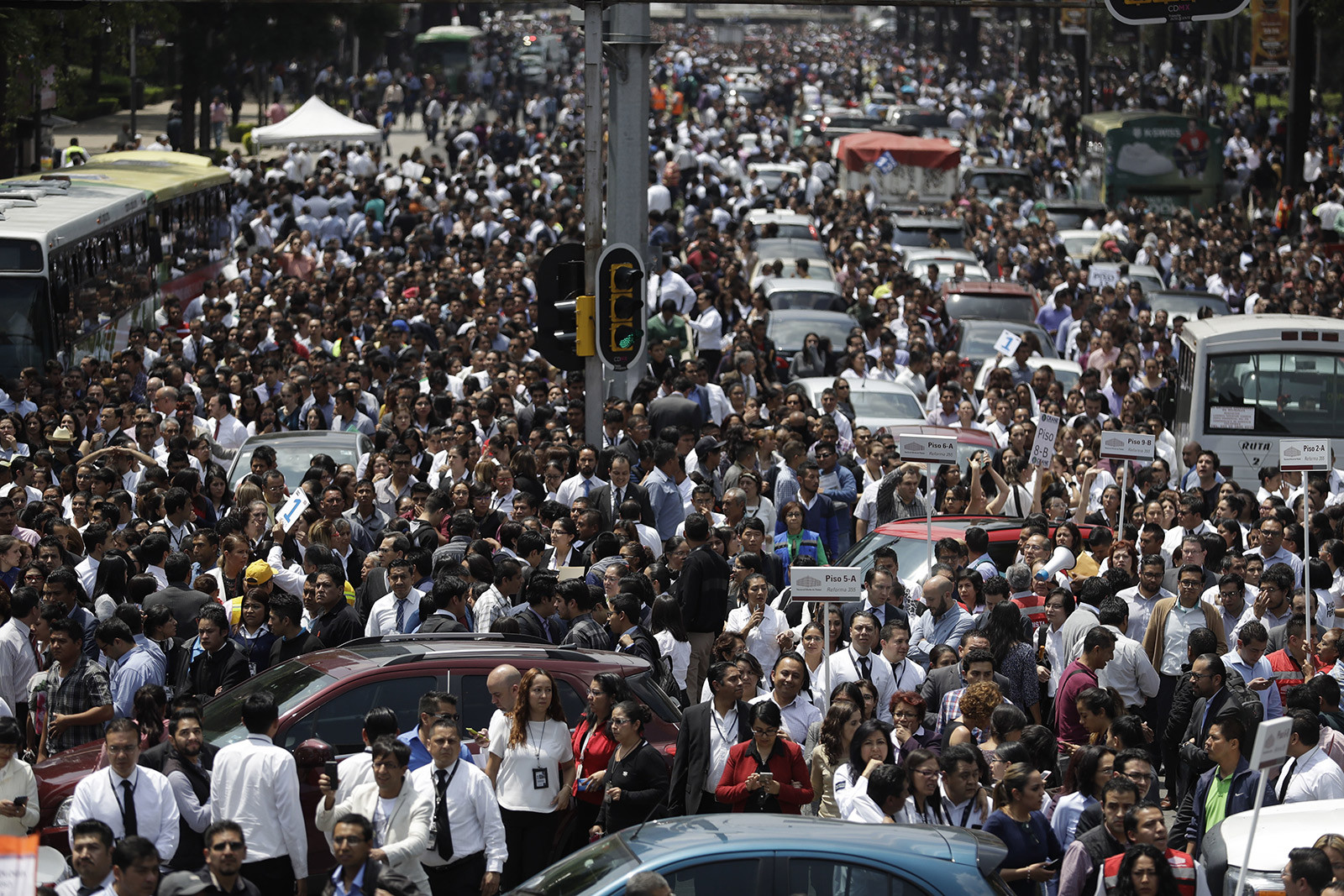 People gather on a Mexico City street after office buildings were evacuated because of the 2017 earthquake.