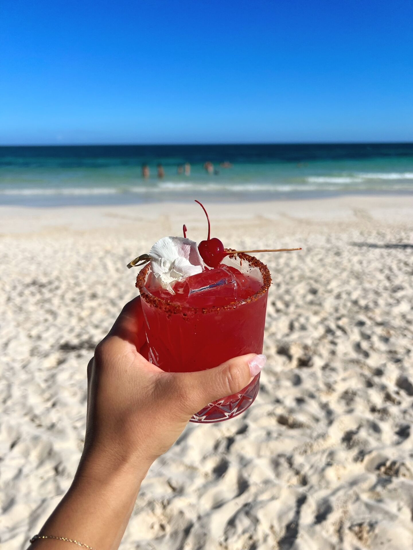 Woman relaxing on a white sand beach with turquoise water on Isla Mujeres