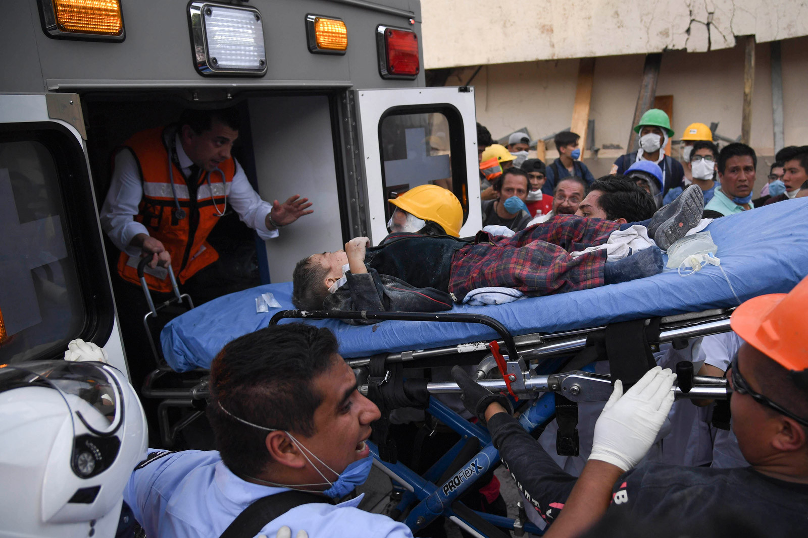 A rescued child is helped away from the collapsed Enrique Rebsamen school in Mexico City after the 2017 earthquake.