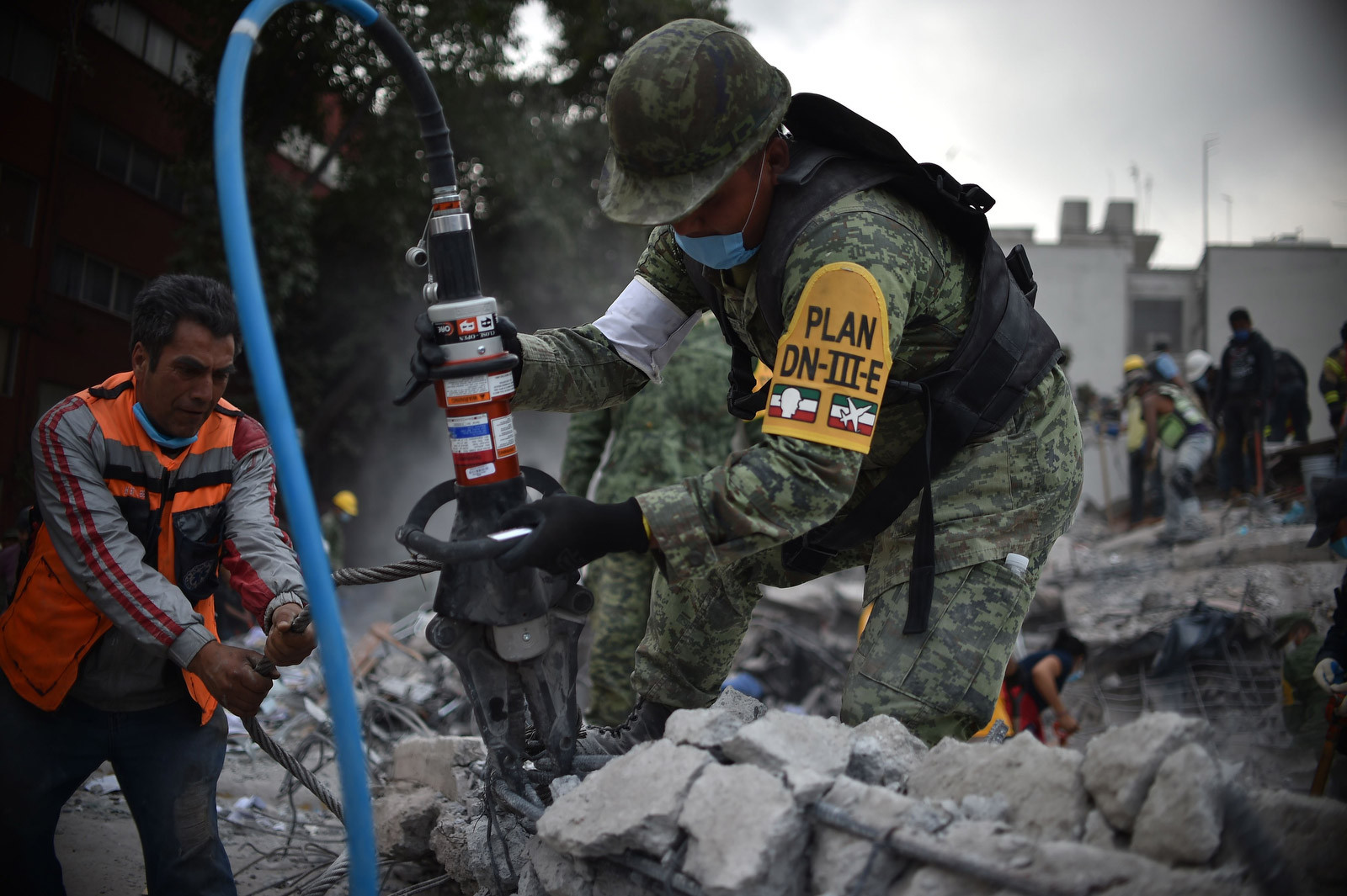 Debris removal from a flattened building in Mexico City, showcasing the scale of destruction caused by the earthquake.