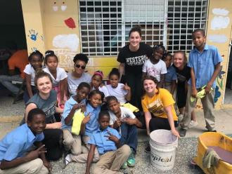 A WMU student with a group of local children in a school in Dominican Republic.