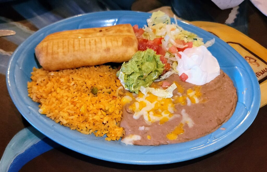 Chimichanga with rice, beans, and toppings at Ay Jalisco