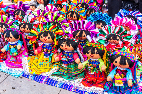 A group of Lelé dolls in various sizes and colors, showcasing their traditional dresses and braids