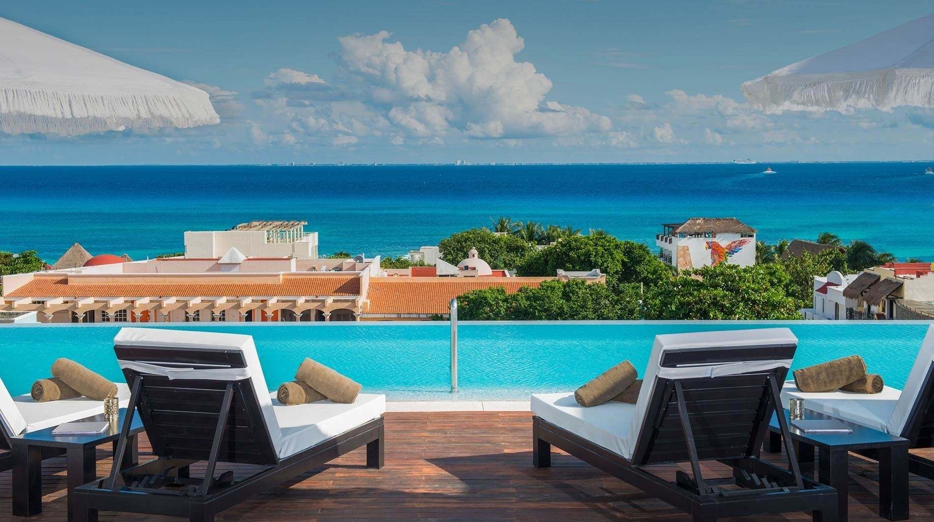 alt= The Beachfront by The Fives Hotels, an adults-only resort, boasts a large pool overlooking the ocean.