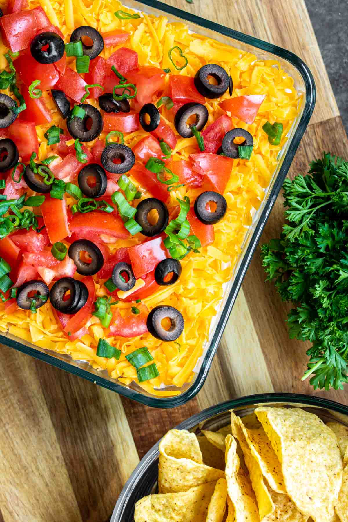 7 Layer Dip and a bowl of tortilla chips