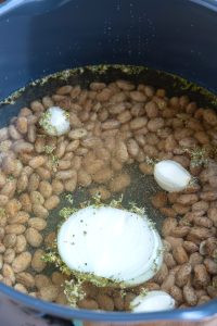 Adding ingredients to the pot with pinto beans