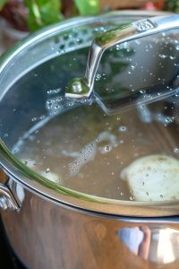 Adding hot water to the simmering beans