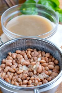 Straining the cooked beans, reserving the broth