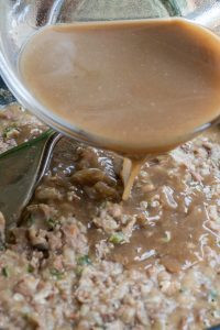 Adding bean broth while mashing the refried beans