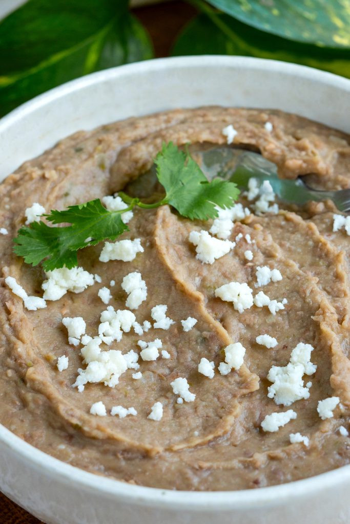 Bowl of refried beans with a spoon, showcasing the creamy texture