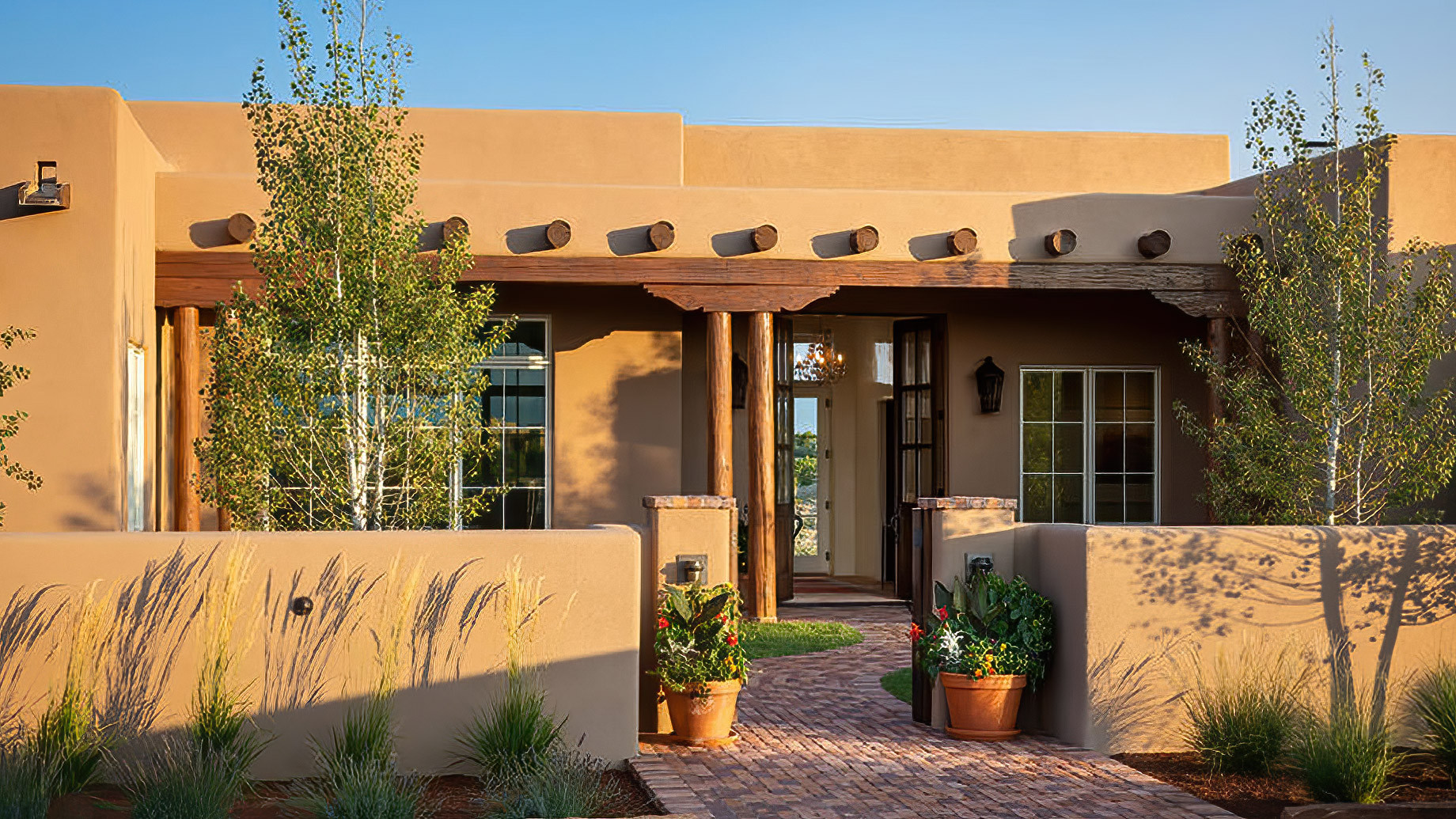 Adobe Style Home Exterior with Rustic Wooden Door and Small Windows