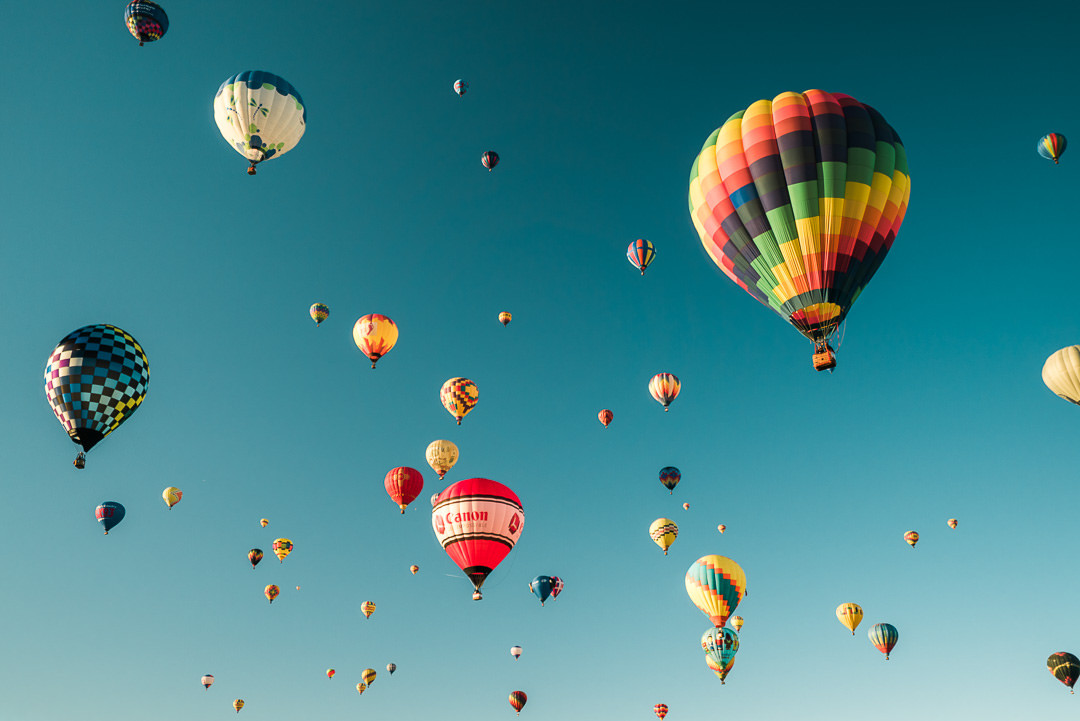 Colorful hot air balloons filling the sky during the mass ascension at the Albuquerque International Balloon Fiesta