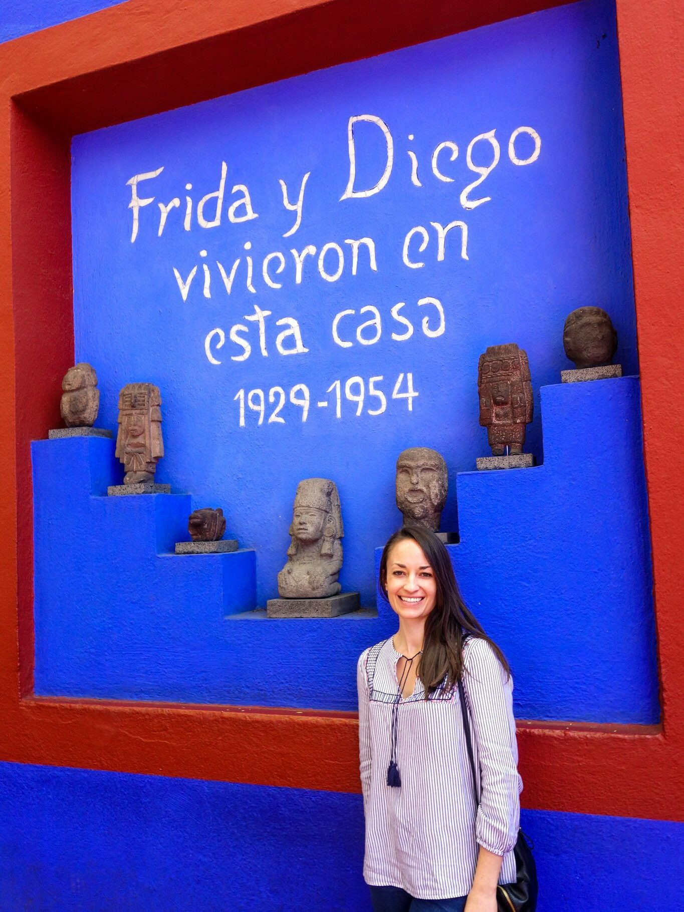 Alysha posing in front of the iconic blue walls of Casa Azul, the Frida Kahlo Museum in Coyoacán.