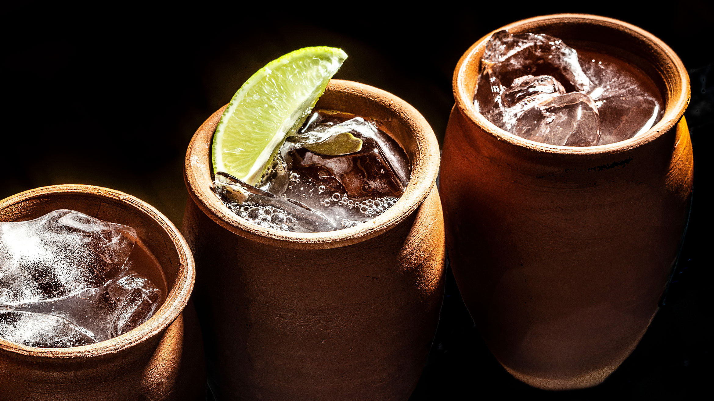 Cantarito cocktail, a Mexican grapefruit and tequila drink served in a traditional clay cantarito cup, garnished with citrus fruits.