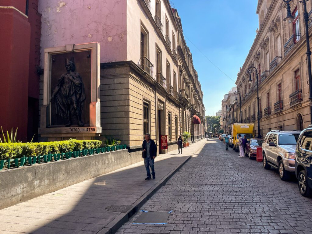 A panoramic view of the historic center of Mexico City, showcasing grand architecture and a bustling city square.