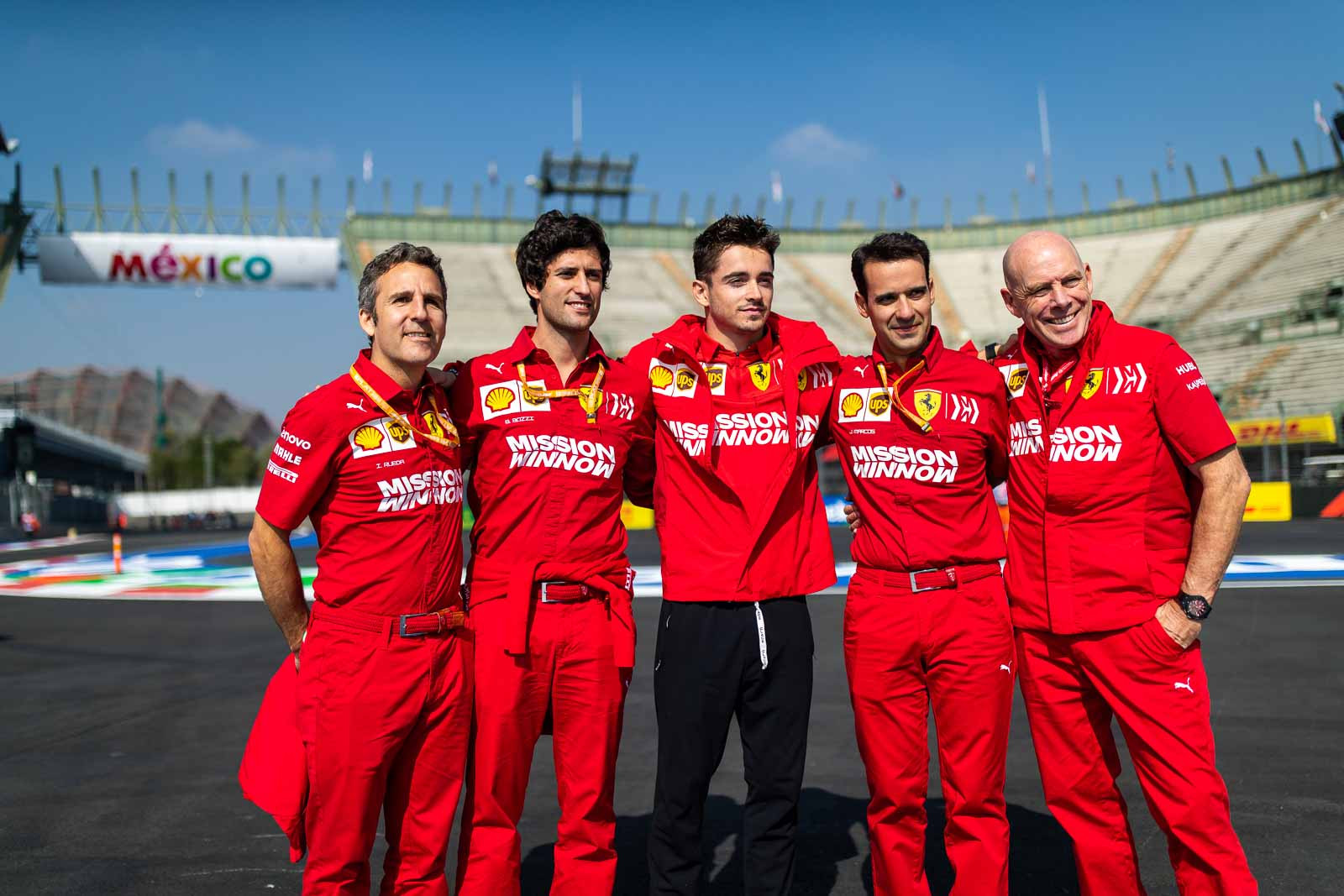 Charles Leclerc and Ferrari team members pose for a polaroid photograph at the Mexican Grand Prix