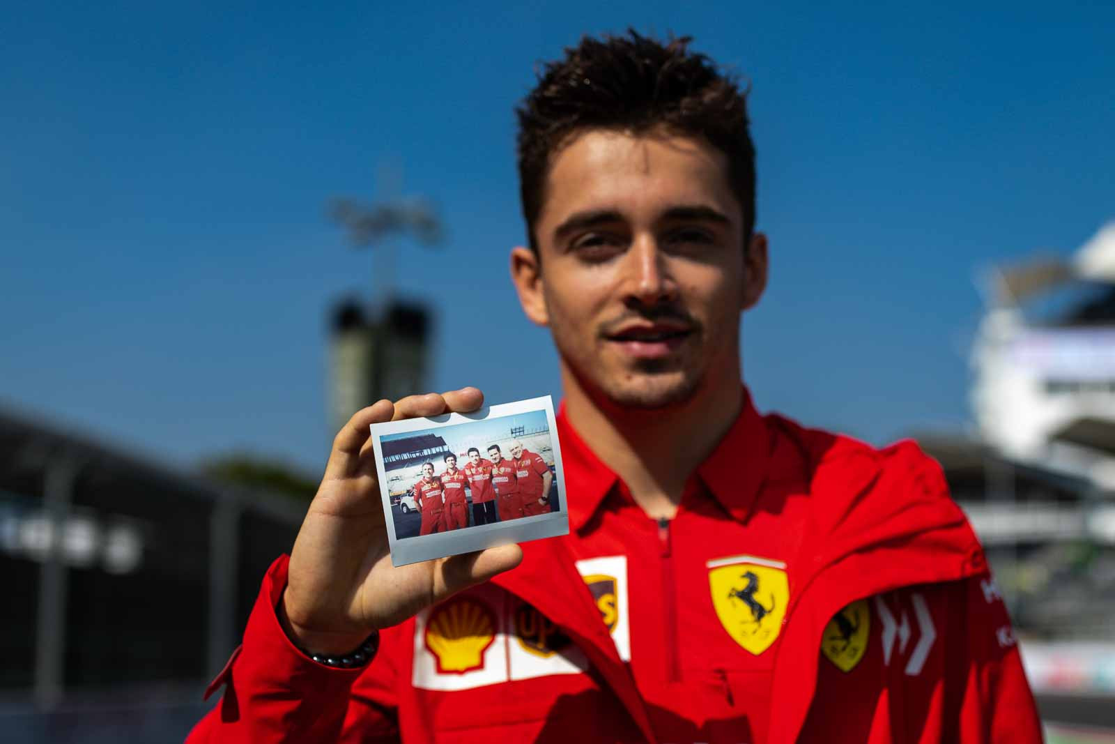 Charles Leclerc poses with a photographer's polaroid picture in the Formula One paddock in Mexico