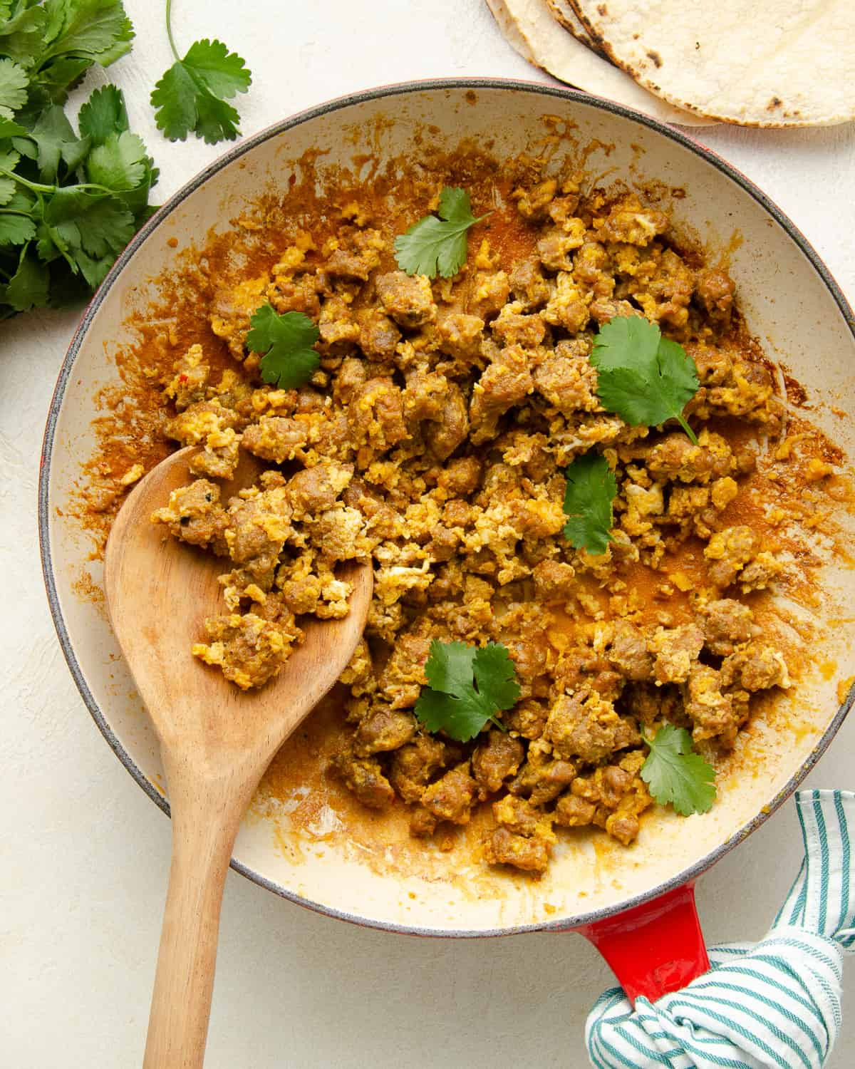 Huevos con chorizo in a skillet, garnished with cilantro.