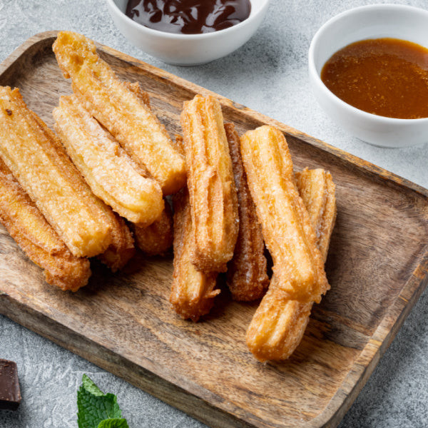 A churros bar with assorted dipping sauces, offering a fun and interactive dessert option for a Mexican fiesta.