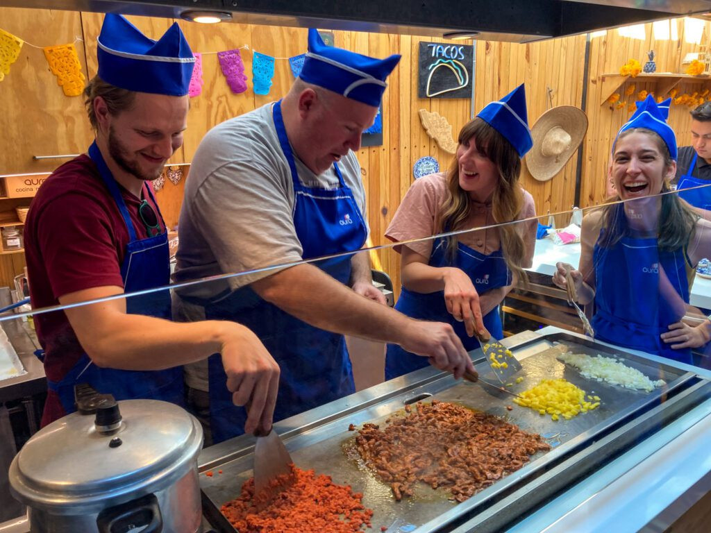 Participants actively engaged in a Mexican cooking class, preparing traditional dishes.