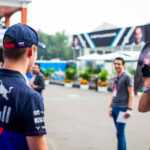 Daniil Kvyat reacts with surprise at seeing a cutout of Kelly Piquet on a photographer's lens during the Mexican Grand Prix paddock walk