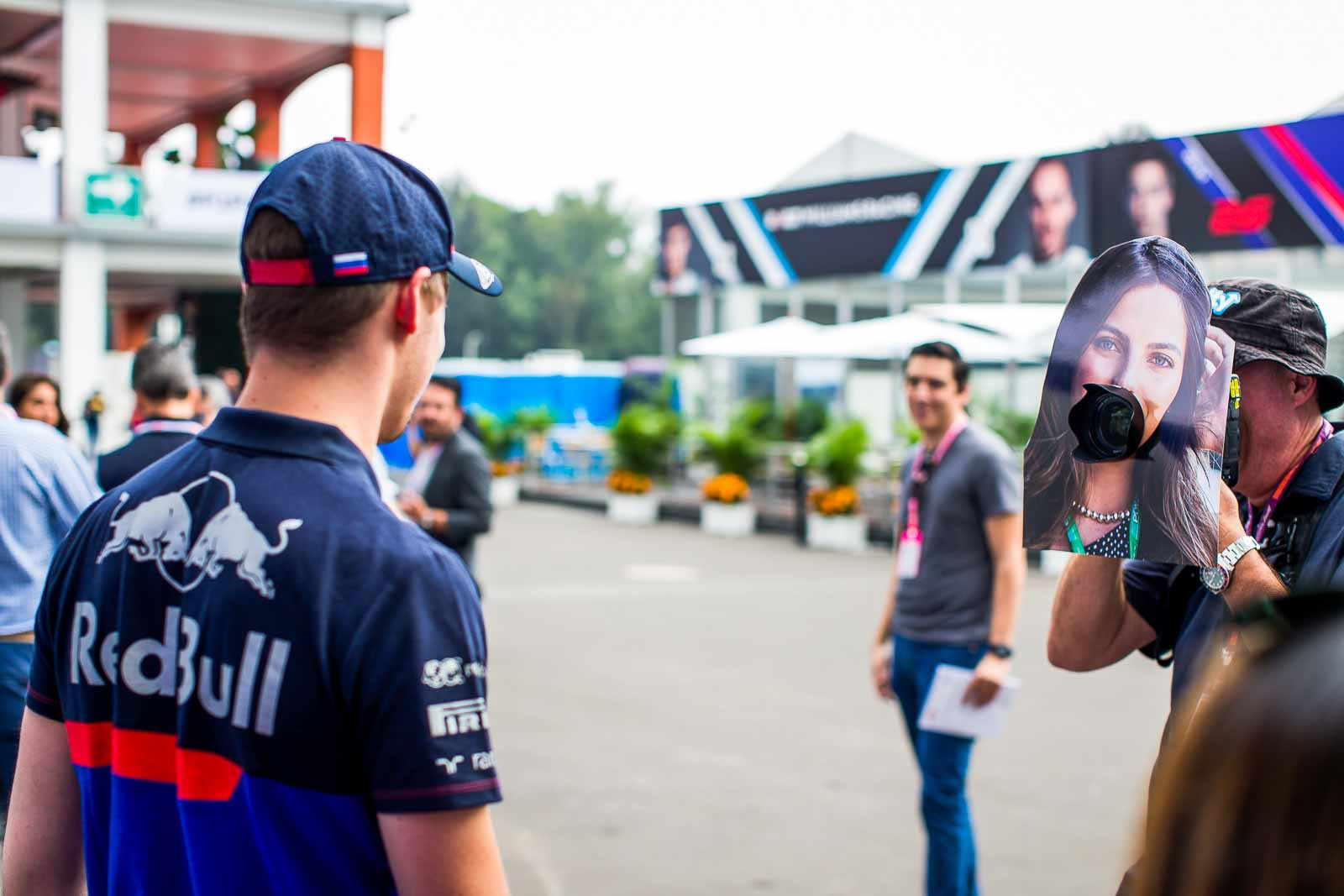 Daniil Kvyat reacts with surprise at seeing a cutout of Kelly Piquet on a photographer's lens during the Mexican Grand Prix paddock walk