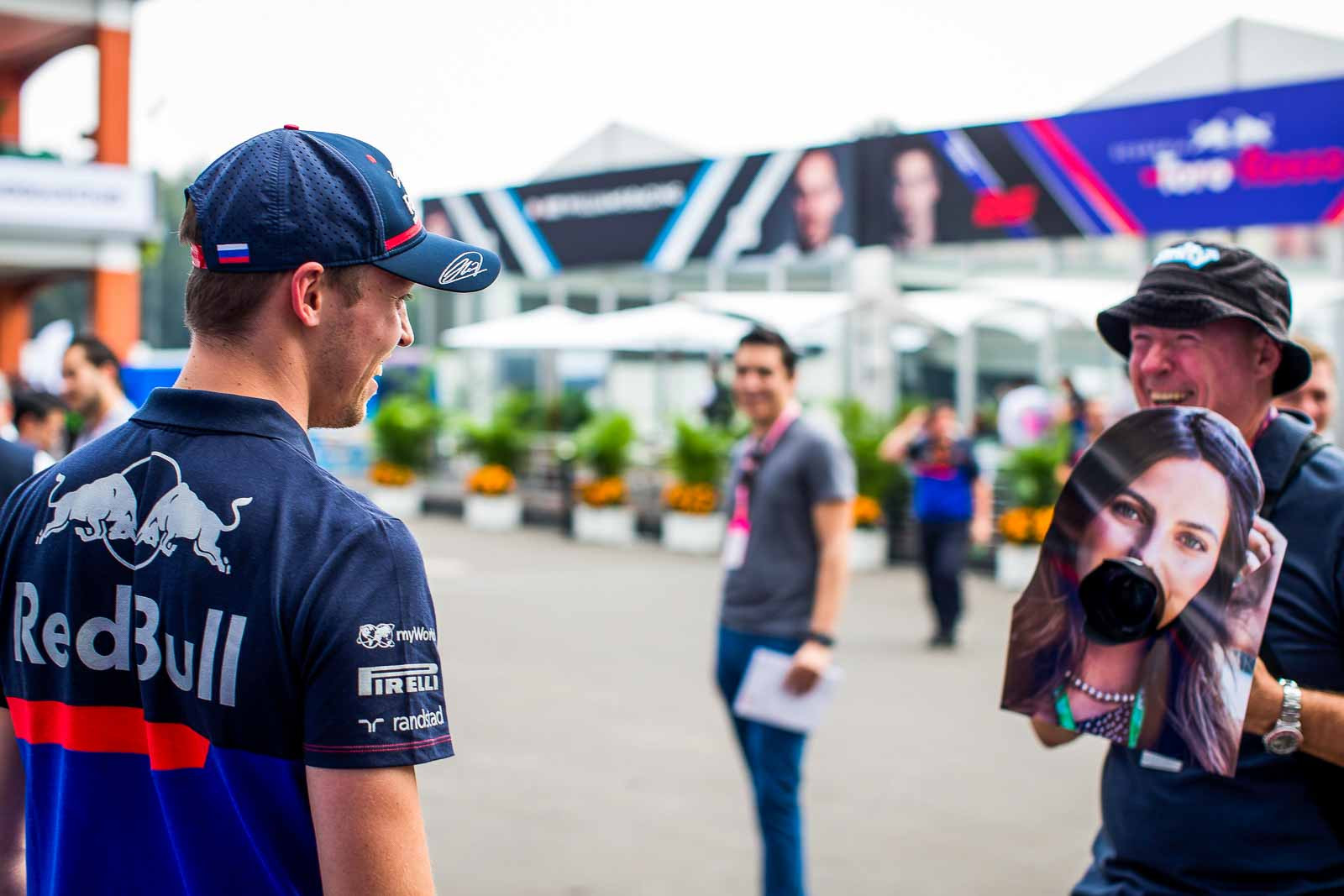 Formula 1 driver Daniil Kvyat laughing while looking at a photo cutout during Mexican Grand Prix paddock interviews