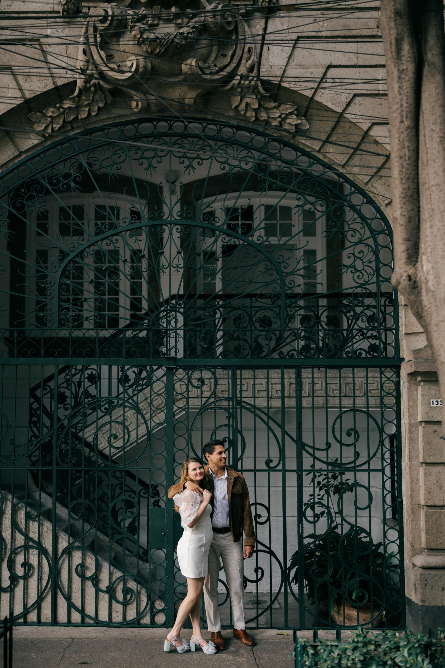 Dreamy mexico pictures:  A couple poses romantically in front of an ornate wrought iron gate, a classic Mexico City backdrop