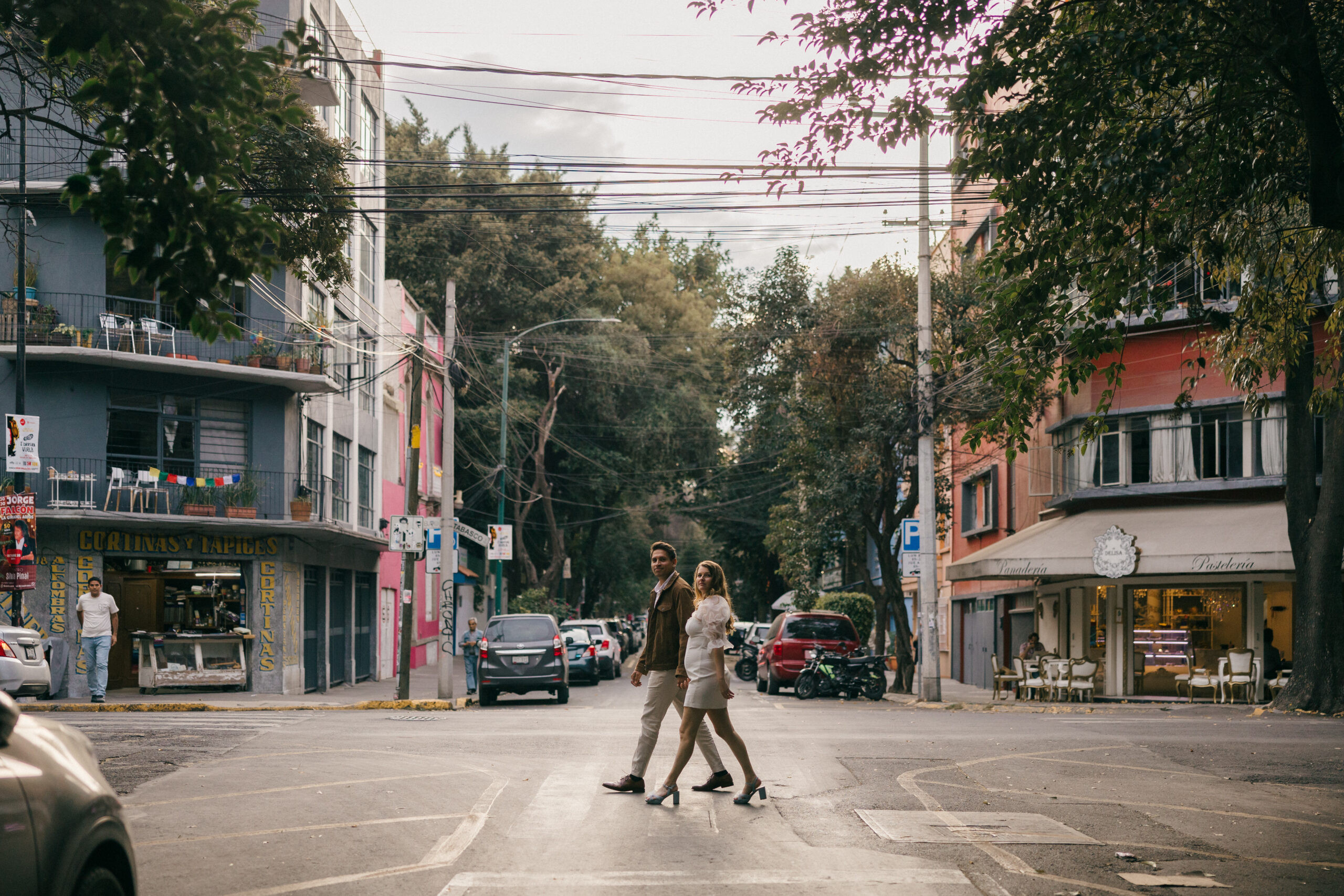 Urban mexico pictures: A beautiful couple walks along a Mexico City street, capturing the vibrant urban landscape in their engagement photos