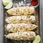 A baking sheet with four cobs of Elote ready to enjoy.