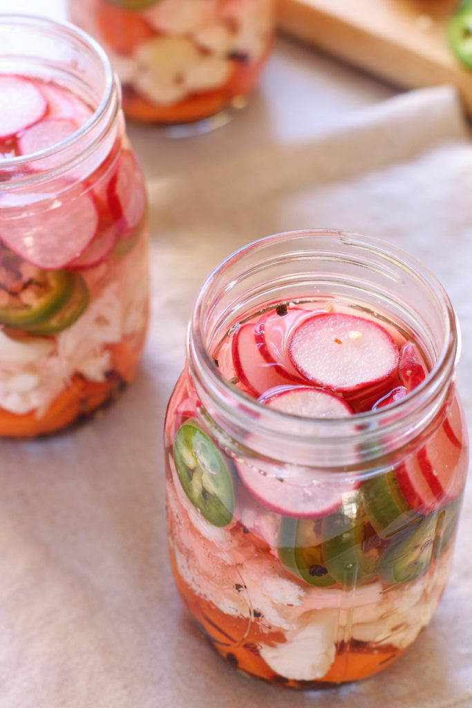 Close-up of vibrant Mexican escabeche with cauliflower, carrots, radishes, and jalapenos