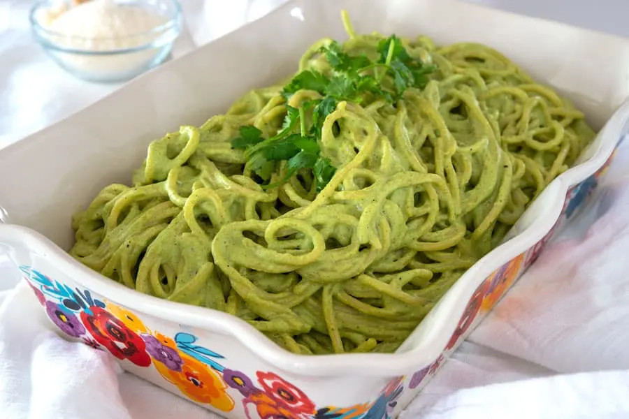 Casserole dish filled with Espagueti Verde, illustrating a family-style serving option and the dish's rich green color