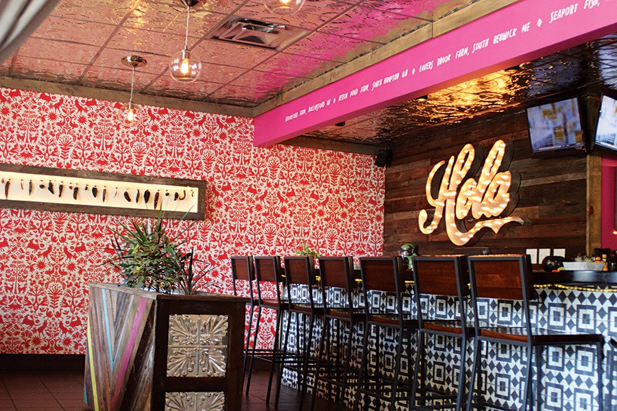 A close-up of Vida Cantina's interior, showing the bar area with patrons and food being served, emphasizing the lively and social dining experience.