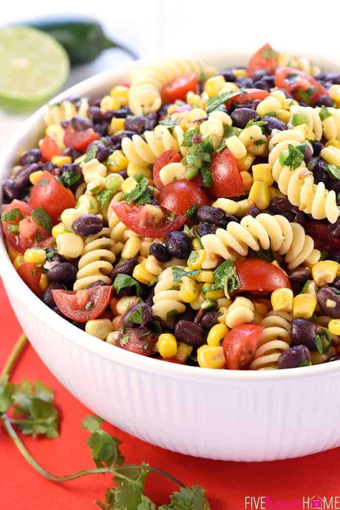 Close up vibrant Mexican Pasta Salad in a white bowl showcasing the fresh ingredients.