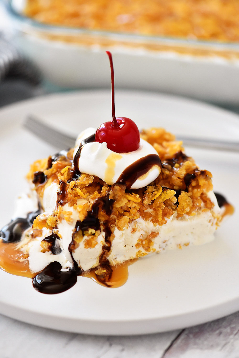 Close-up of Mexican Fried Ice Cream Dessert showcasing its crispy cornflake crust, creamy cinnamon ice cream center, and drizzled chocolate and caramel sauces.