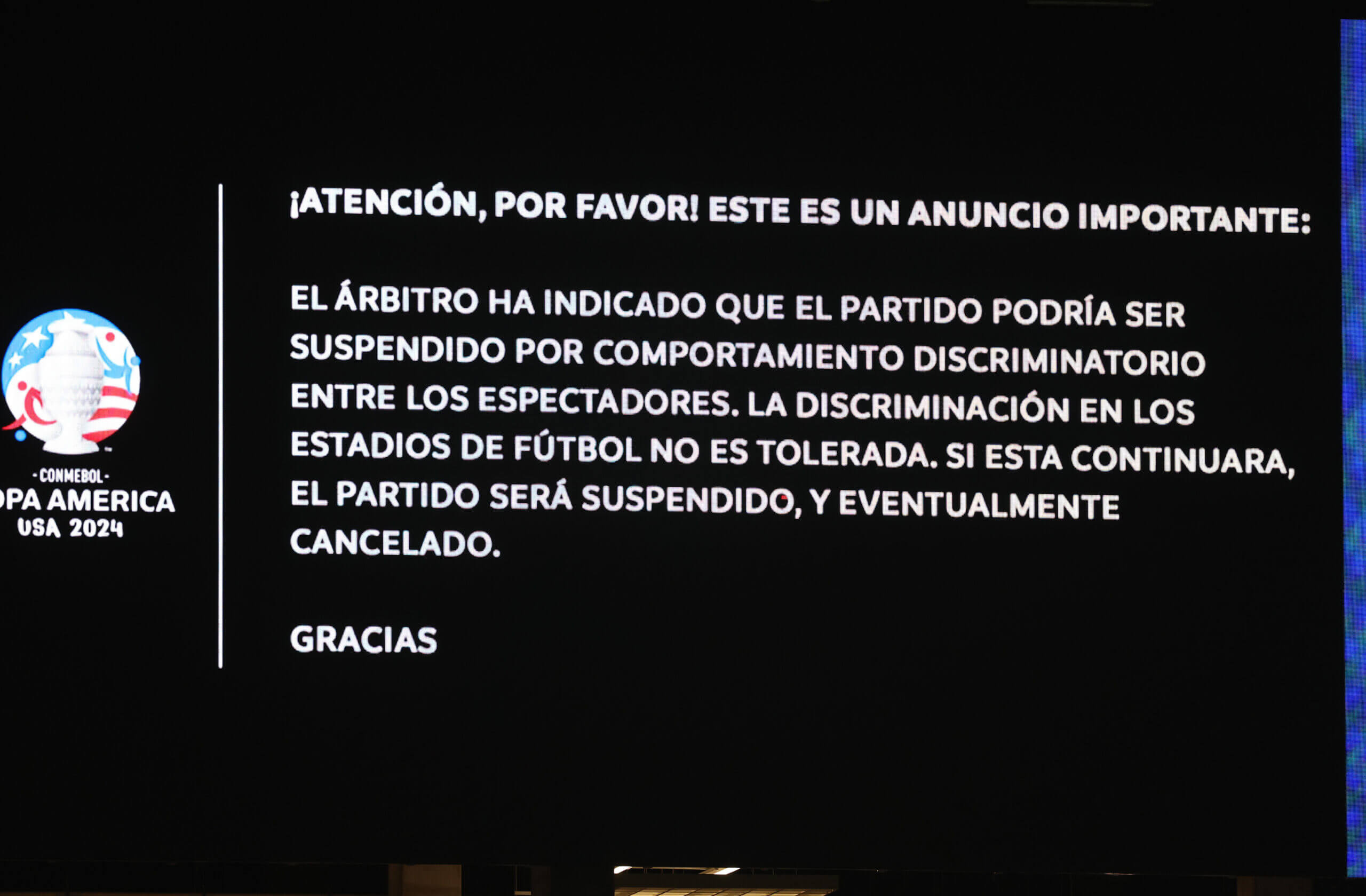 Message displayed on the LED screen warning fans about discriminatory behavior.