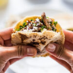 A plate of gorditas filled with various toppings.