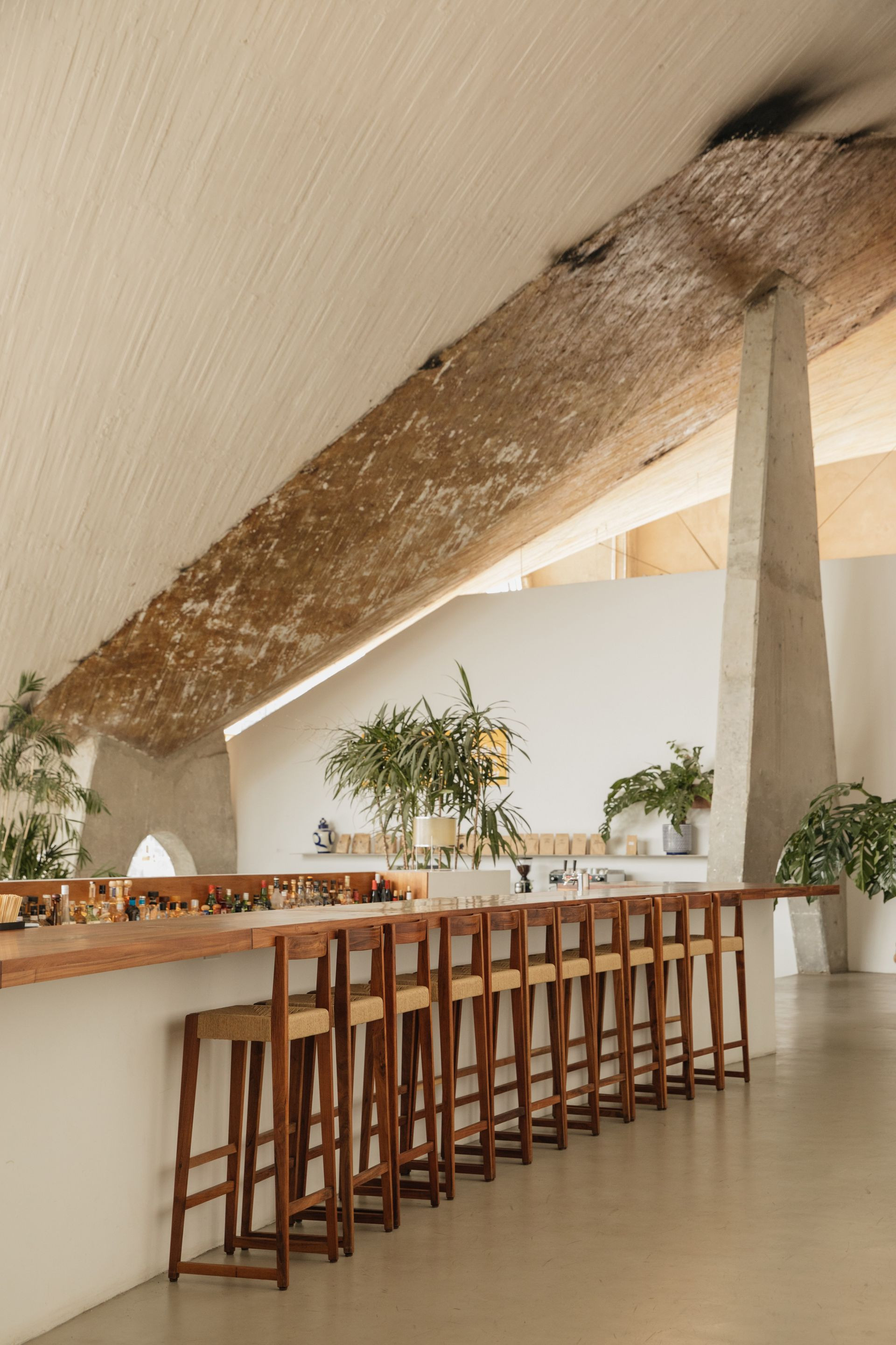 Modern bar area at Lago / Algo in Mexico City, featuring a concrete ceiling and stylish, minimalist design