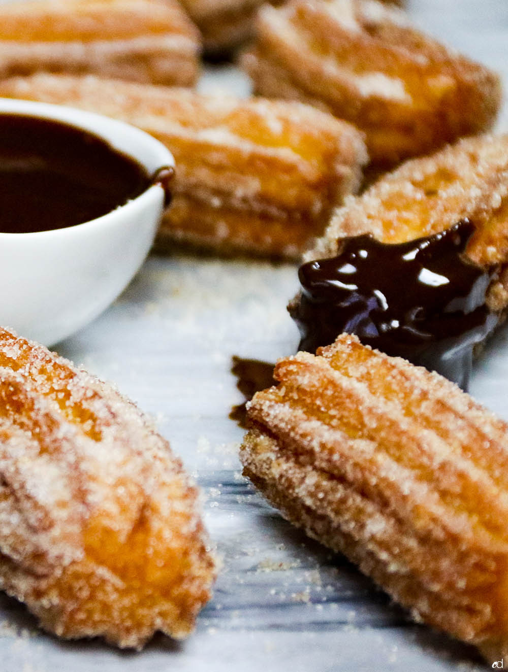 Mexican churro broken in half to reveal the light and airy inside, with cinnamon sugar coating visible, inviting a closer look at the texture.