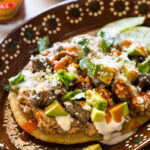 A delicious huarache topped with various ingredients.