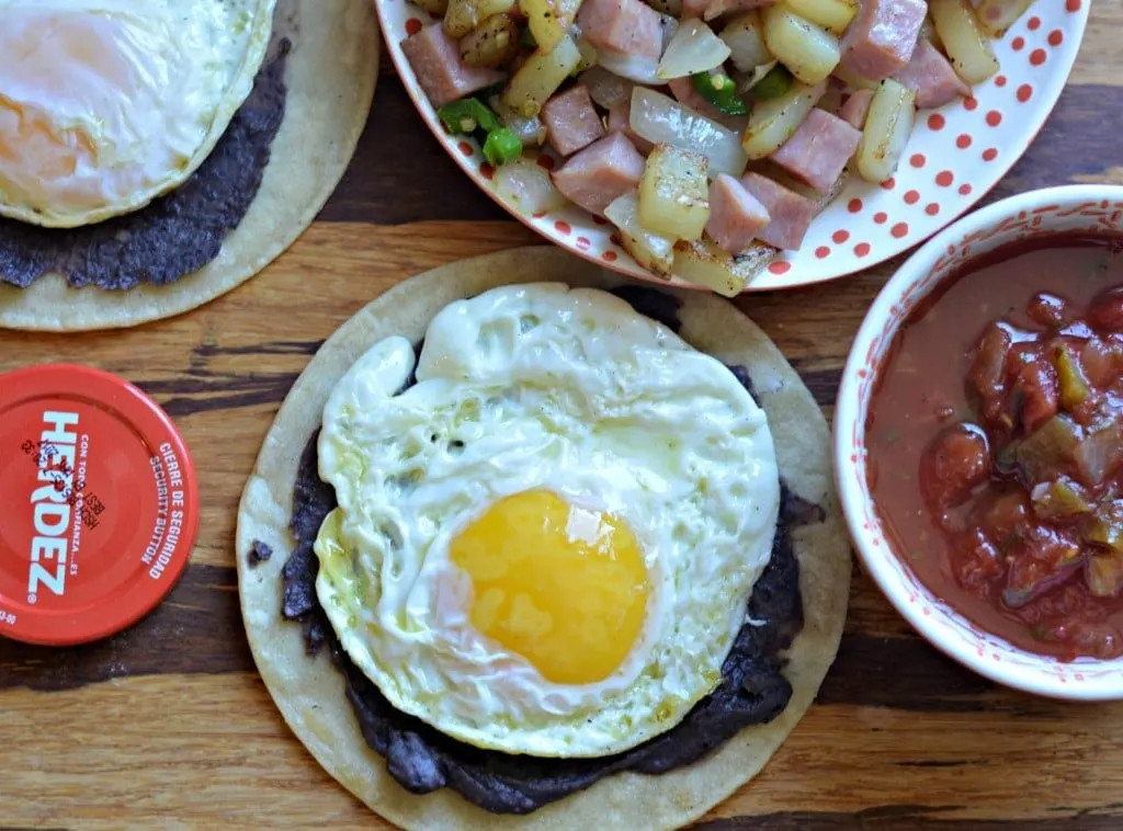 Close-up of authentic Huevos Rancheros, showcasing the layers of fried egg, beans, salsa, and cheese, a classic Mexican breakfast dish.