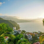 Lush hillside overlooking the turquoise ocean in Puerto Vallarta, Mexico, showcasing a safe and beautiful vacation spot.