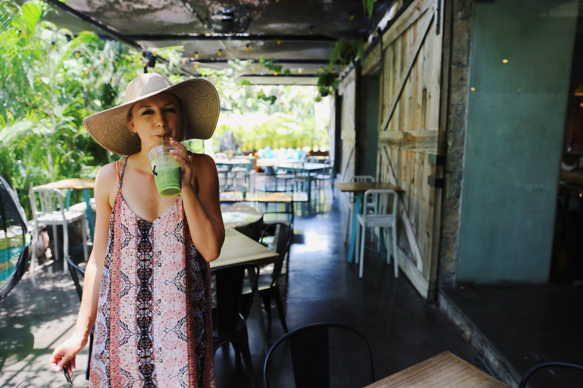 Woman enjoying a green juice at Loot cafe in Zihuatanejo, Mexico