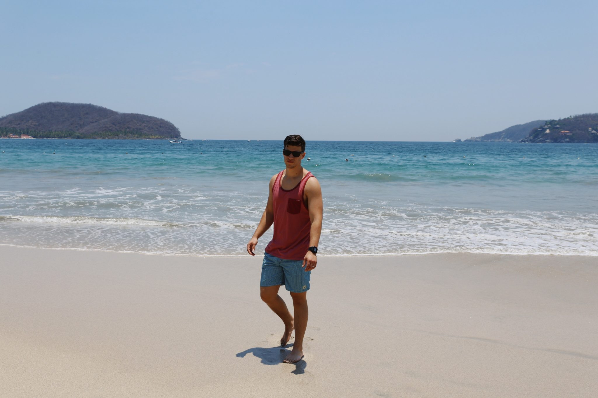 Man relaxing in a hammock on the beach in Zihuatanejo, Mexico