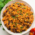 large bowl of spanish rice and beans on white background
