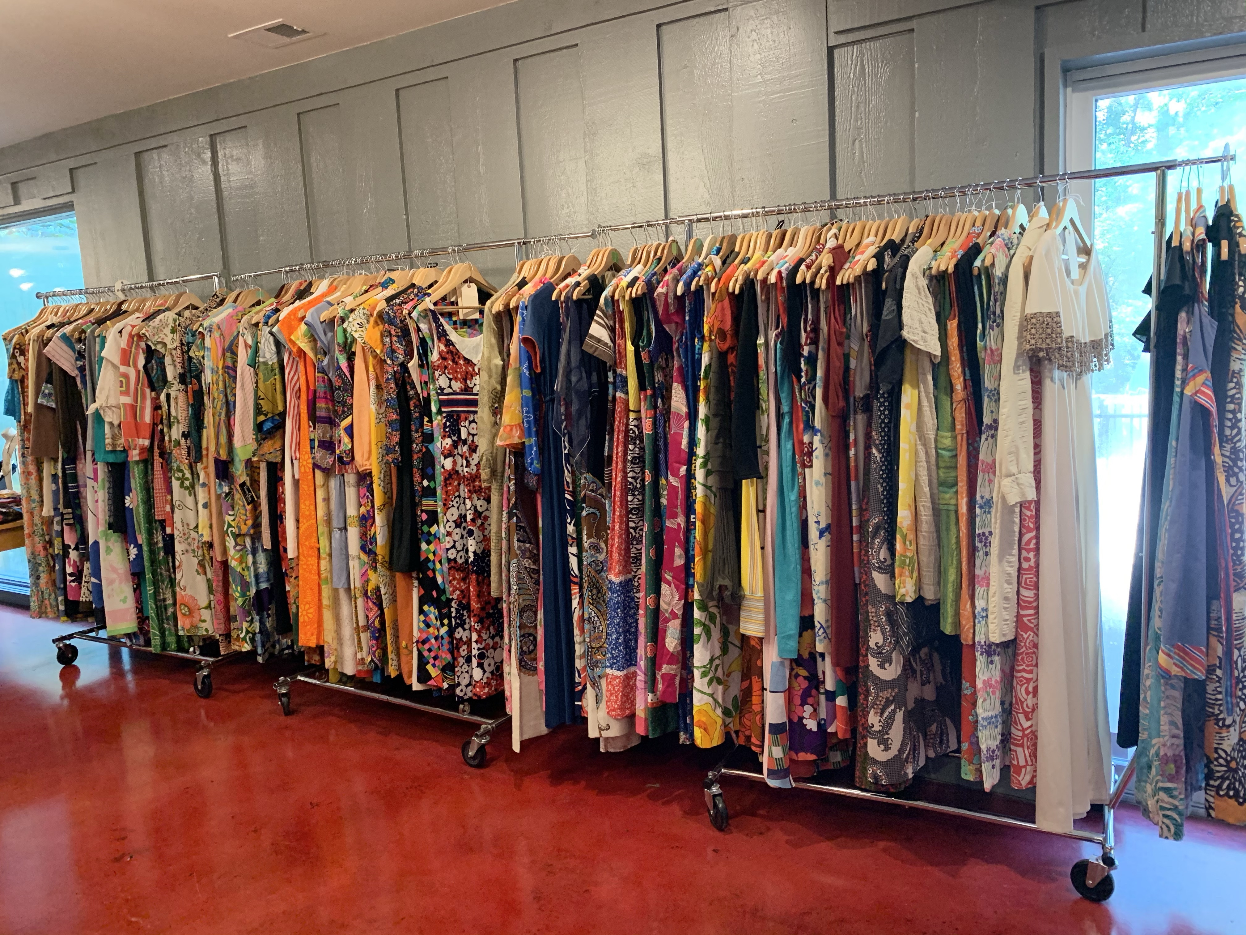 Rows of vintage clothing, featuring a selection of Mexican dresses at a vintage sale