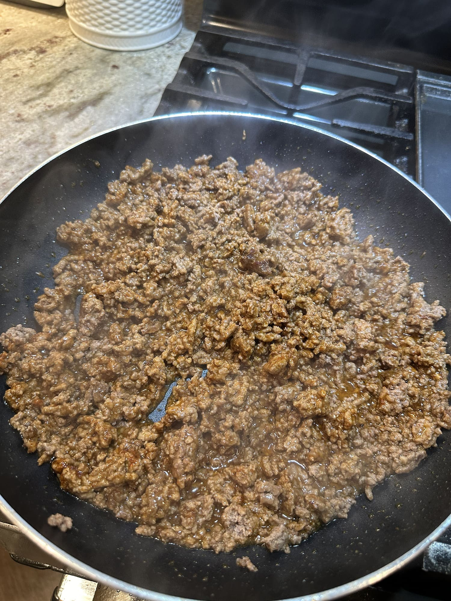 Cooked and seasoned ground beef in a skillet, ready to be used as a filling for Taco Bell Mexican Pizza.