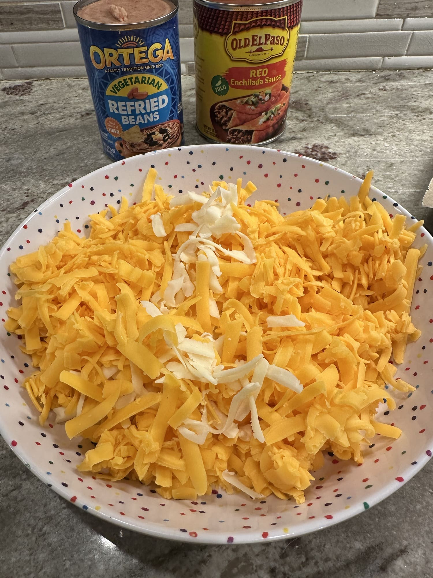 Close-up of hand-shredded cheddar and Monterey Jack cheese, highlighting the texture and lack of powdery coating.