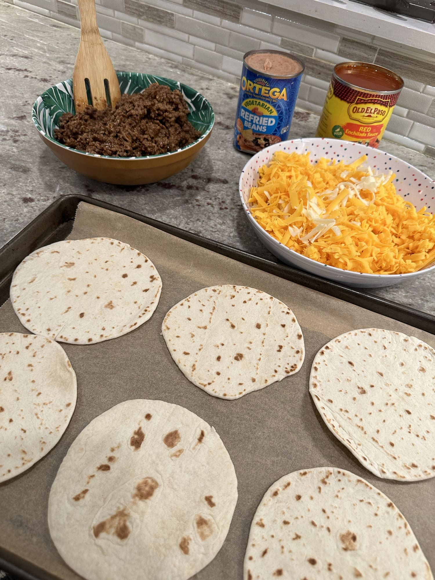 Ingredients for Taco Bell Mexican Pizza: small tortillas, canola oil, red enchilada sauce, ground beef, taco seasoning, refried beans, cheddar cheese, and Monterey Jack cheese.