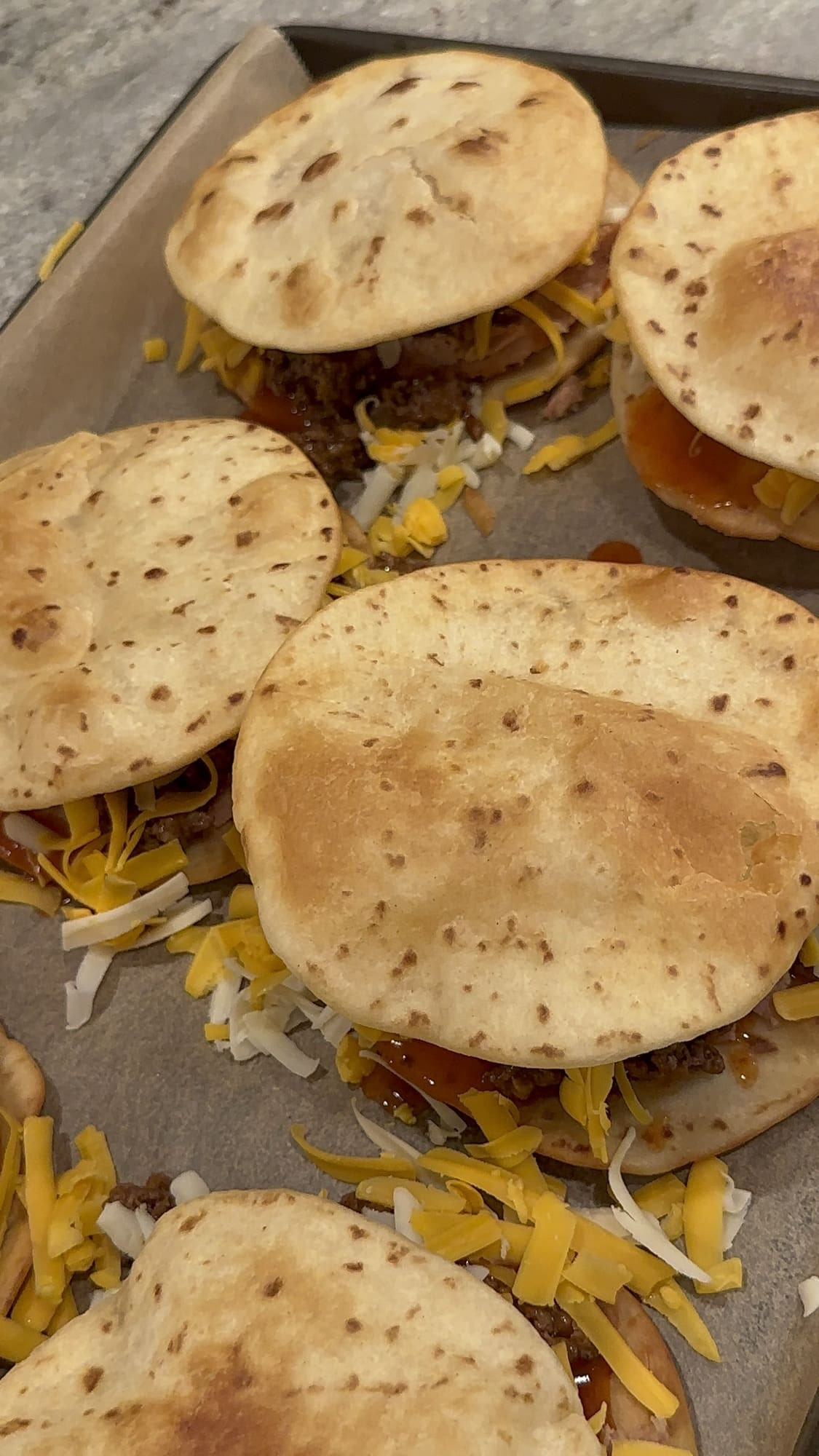 Adding a second fried tortilla on top of the cheese and beef layer to create the double-decker Taco Bell Mexican Pizza.